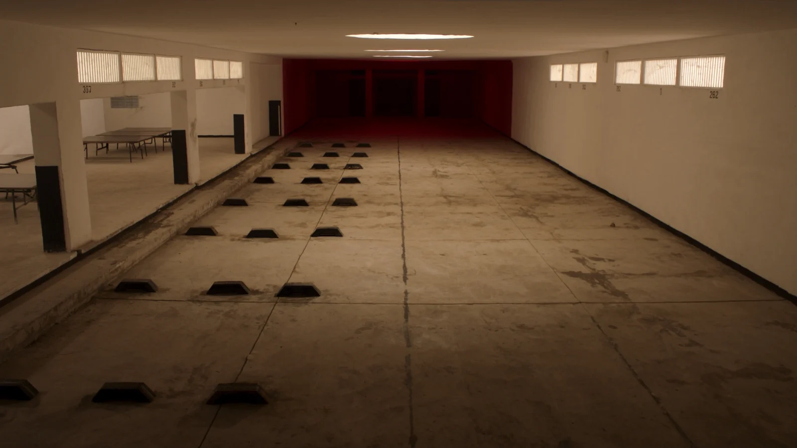 Garagem de condomínio residencial com vagas demarcadas e numeradas
